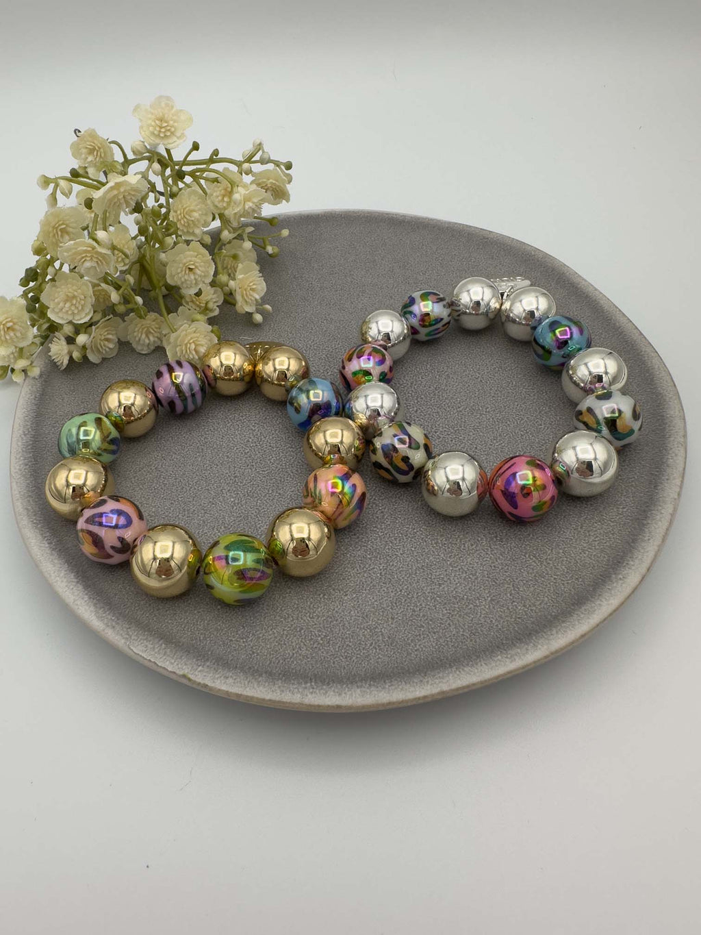 Elastisches Perlenarmband mit grossen goldfarbenen Kugeln und schillernden bunten Effektperlen