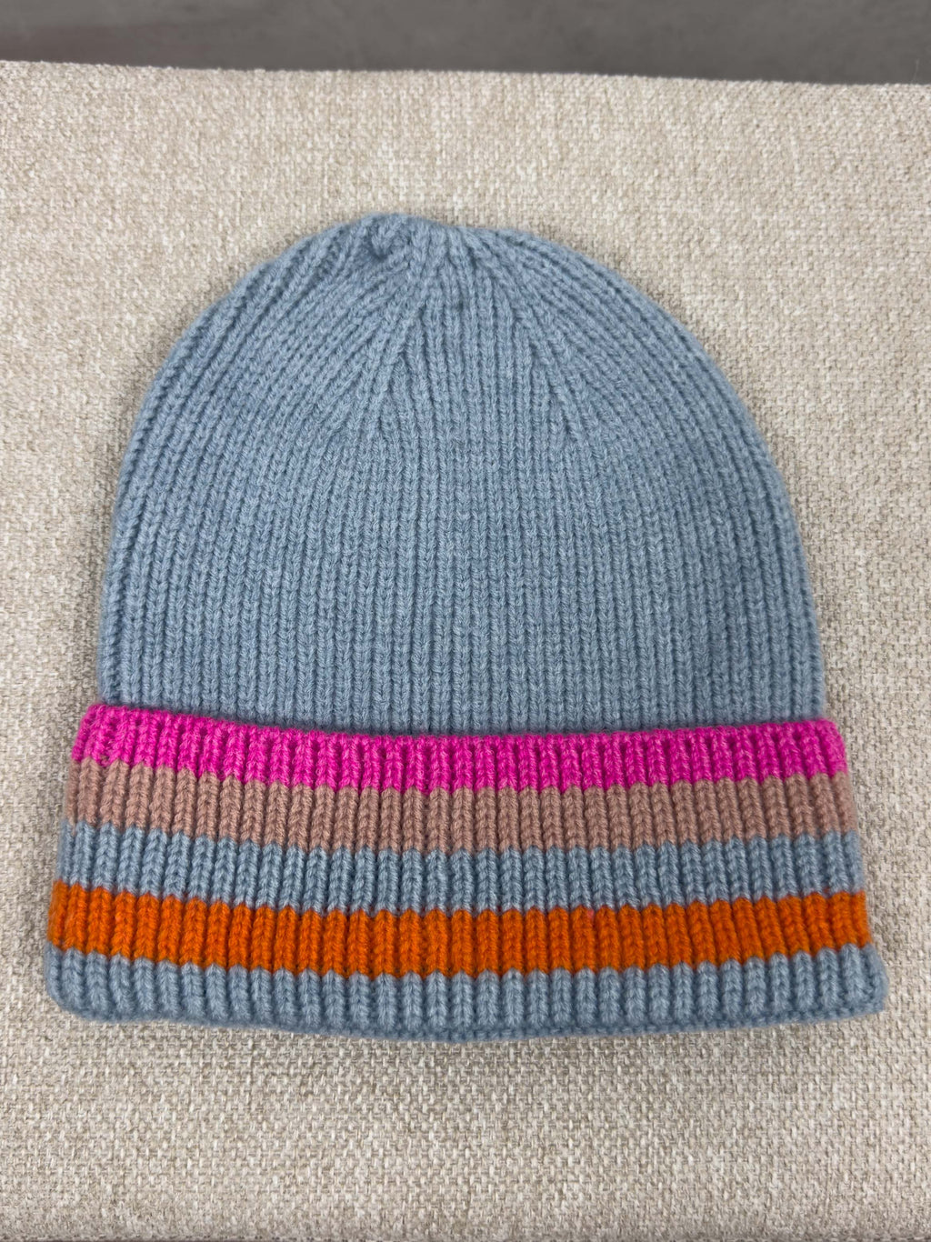 Hellblaue Strickmuetze mit geripptem Muster und breitem Umschlag mit Streifen in Pink, Beige, Orange und Hellblau