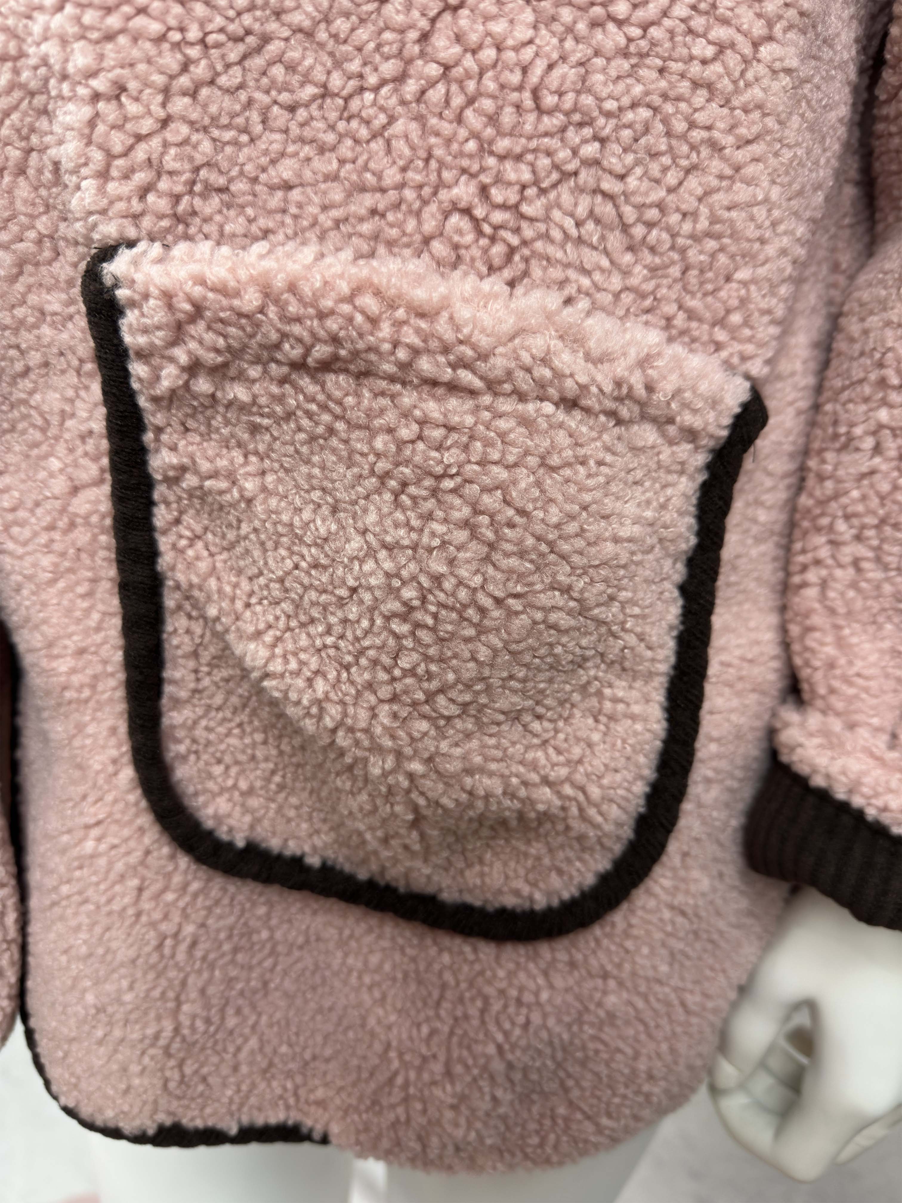 Detailansicht der aufgesetzten Tasche der Teddyjacke „Rosie“ mit Kontrastkante